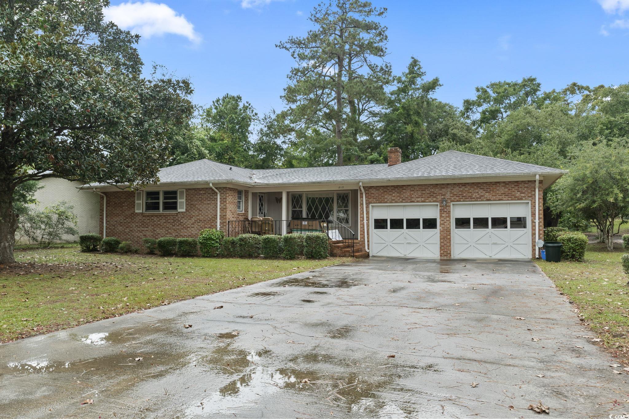 Ranch-style house featuring a porch, a garage, and