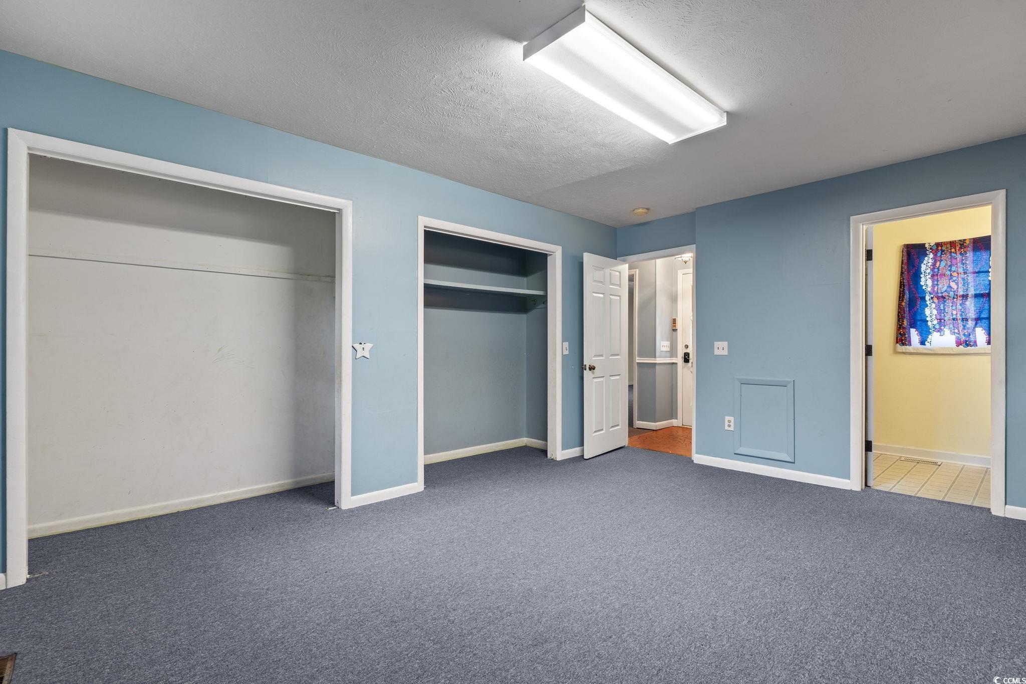813 Bellamy Road North Myrtle Beach, SC 29582 - Photo 13 of 29 Unfurnished bedroom with dark carpet, a textured c
