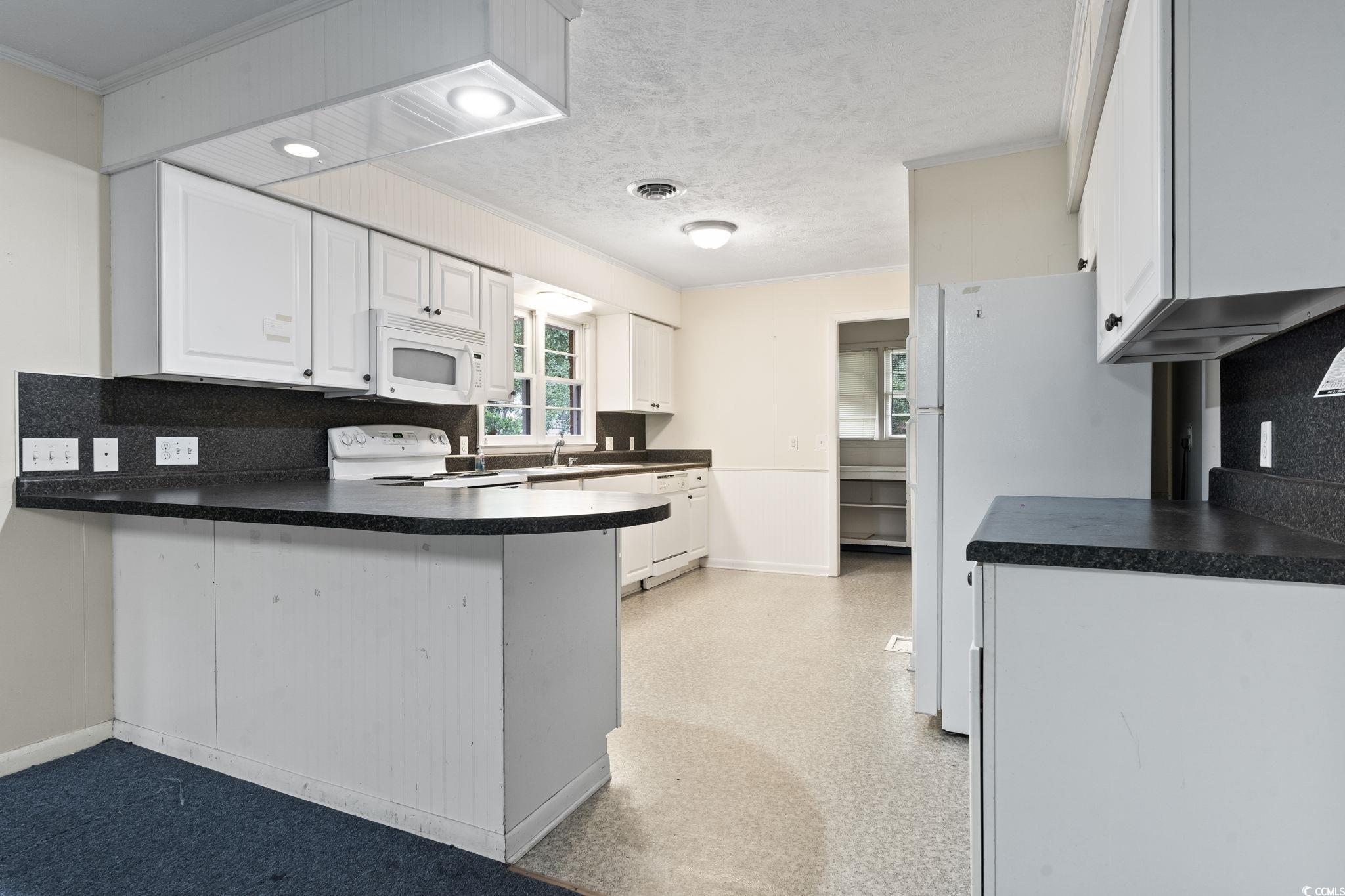 Kitchen featuring white cabinets, kitchen peninsul