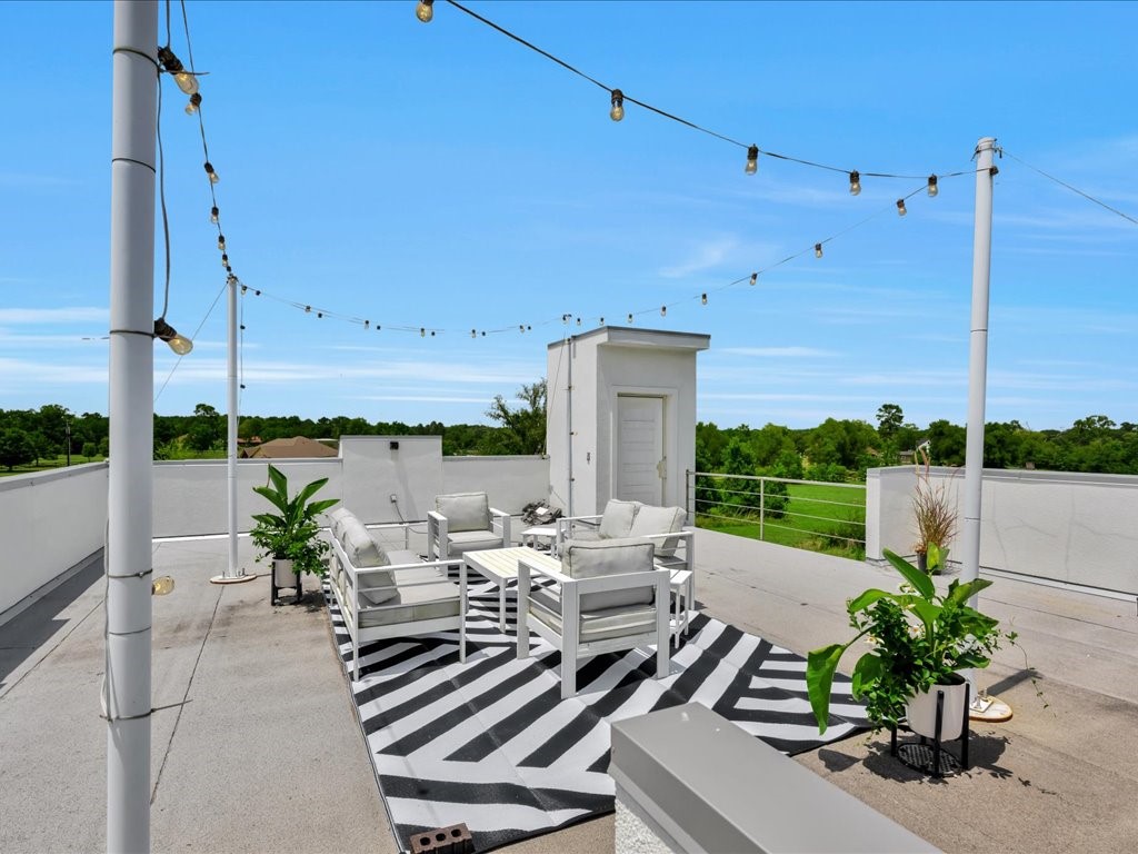 129 White Oak Loop Lufkin, TX 75901 - Photo 39 of 50 a view of a patio with lawn chairs potted plants and a palm tree