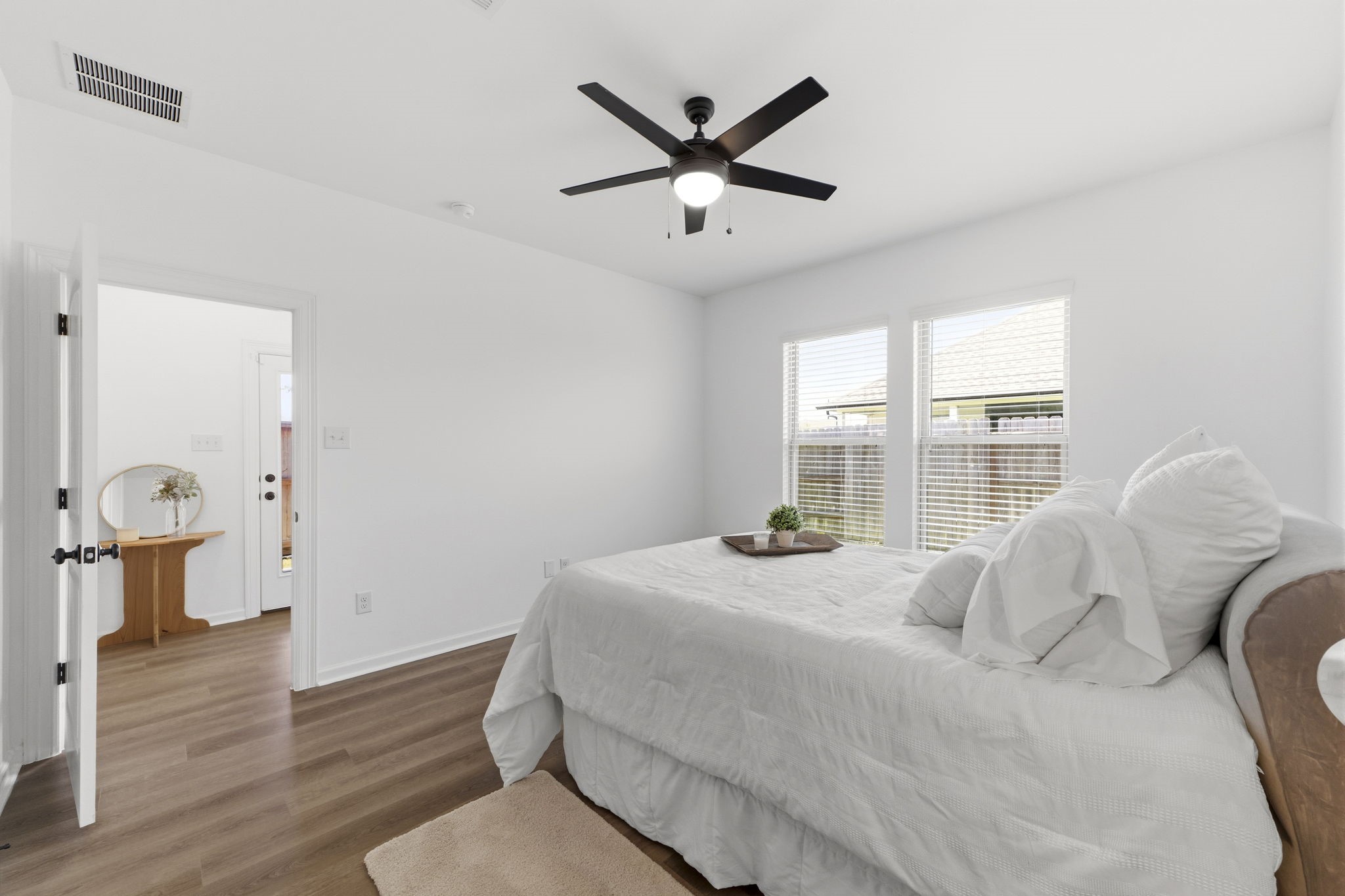 10934 Bonfire Trail Beasley, TX 77417 - Photo 13 of 32 Light-filled primary bedroom offering a spacious layout, ceiling fan, and luxury vinyl plank flooring.