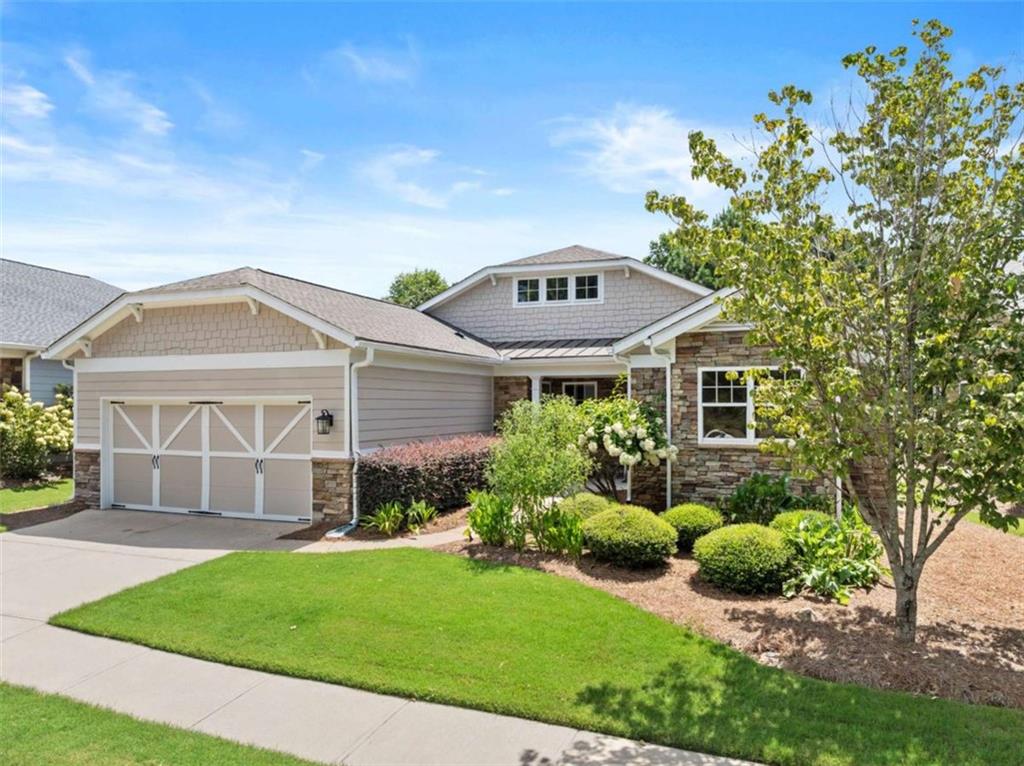 a front view of a house with a garden and yard