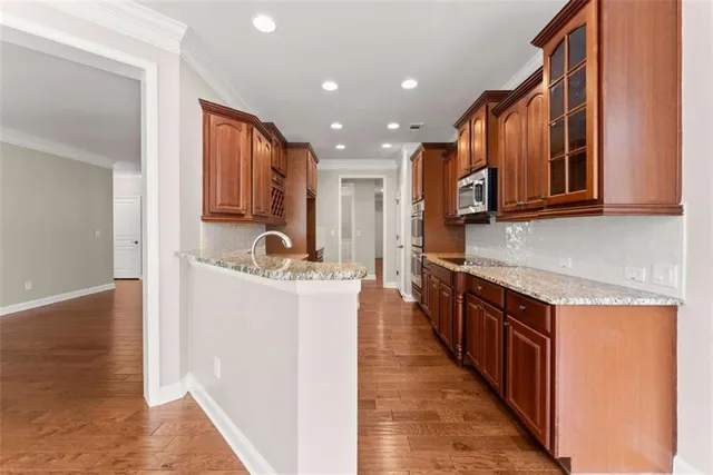 a kitchen with stainless steel appliances kitchen island granite countertop a stove and a sink