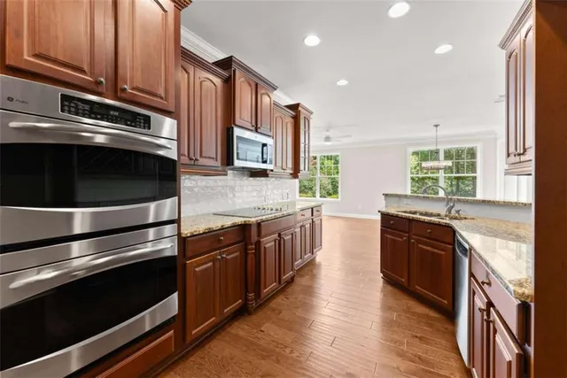 a kitchen with stainless steel appliances granite countertop a refrigerator and a stove