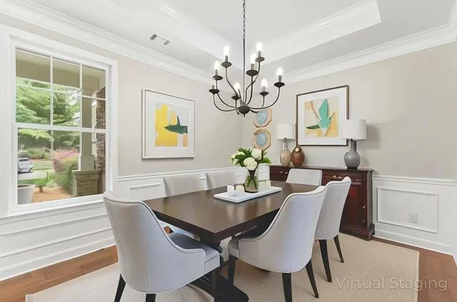 a view of a dining room with furniture a chandelier and a window