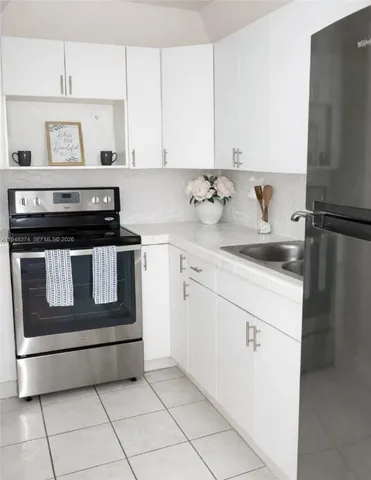 a kitchen with granite countertop white cabinets and white appliances