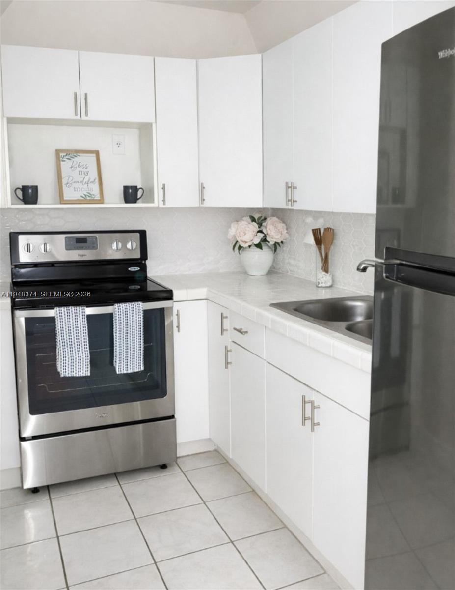 a kitchen with granite countertop white cabinets and white appliances