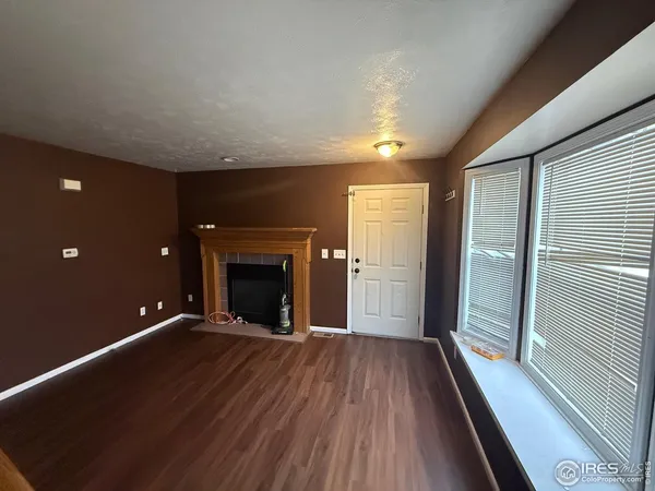 a view of an empty room with a fireplace and a window