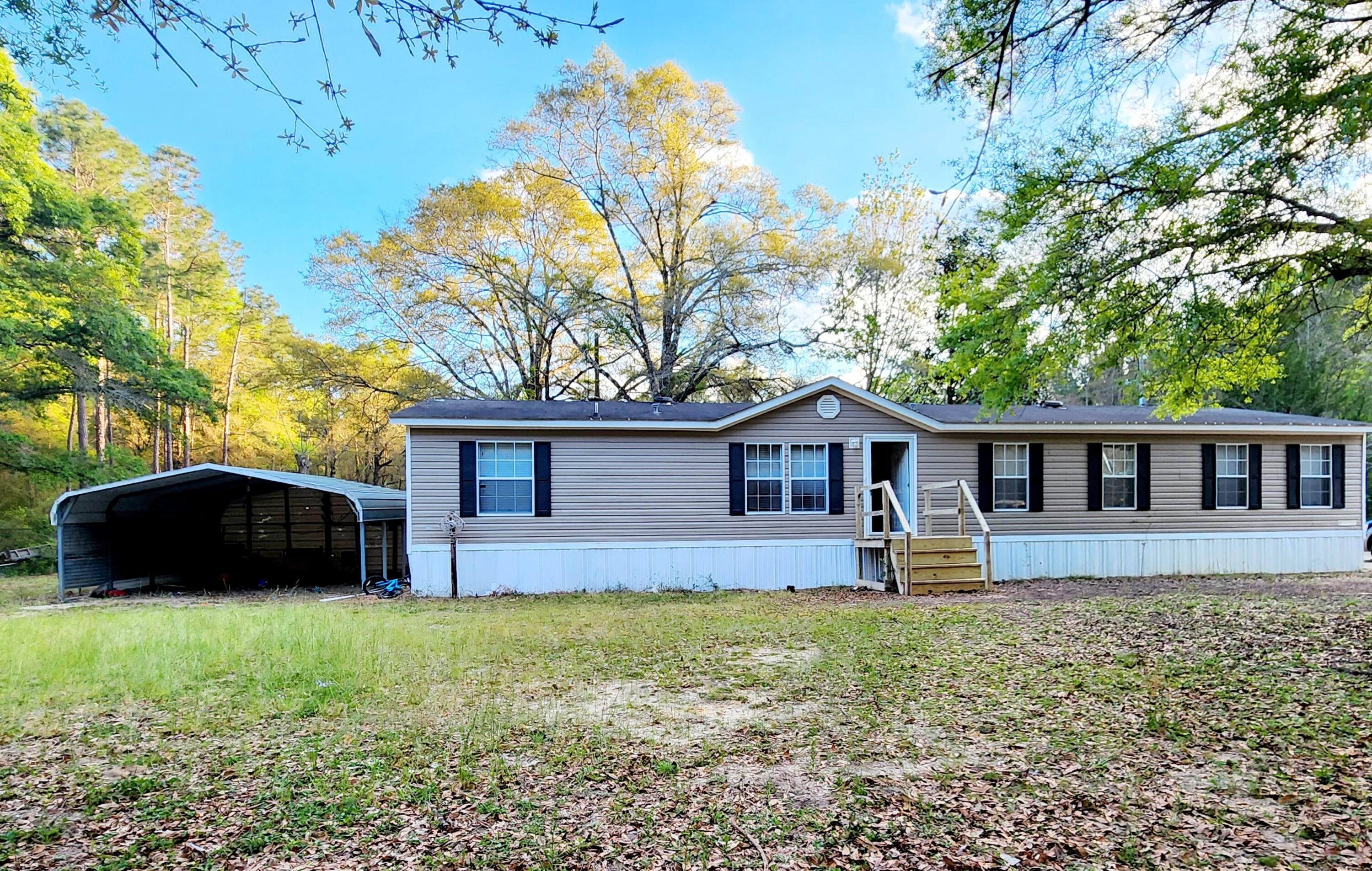 a front view of house with yard and trees in the background