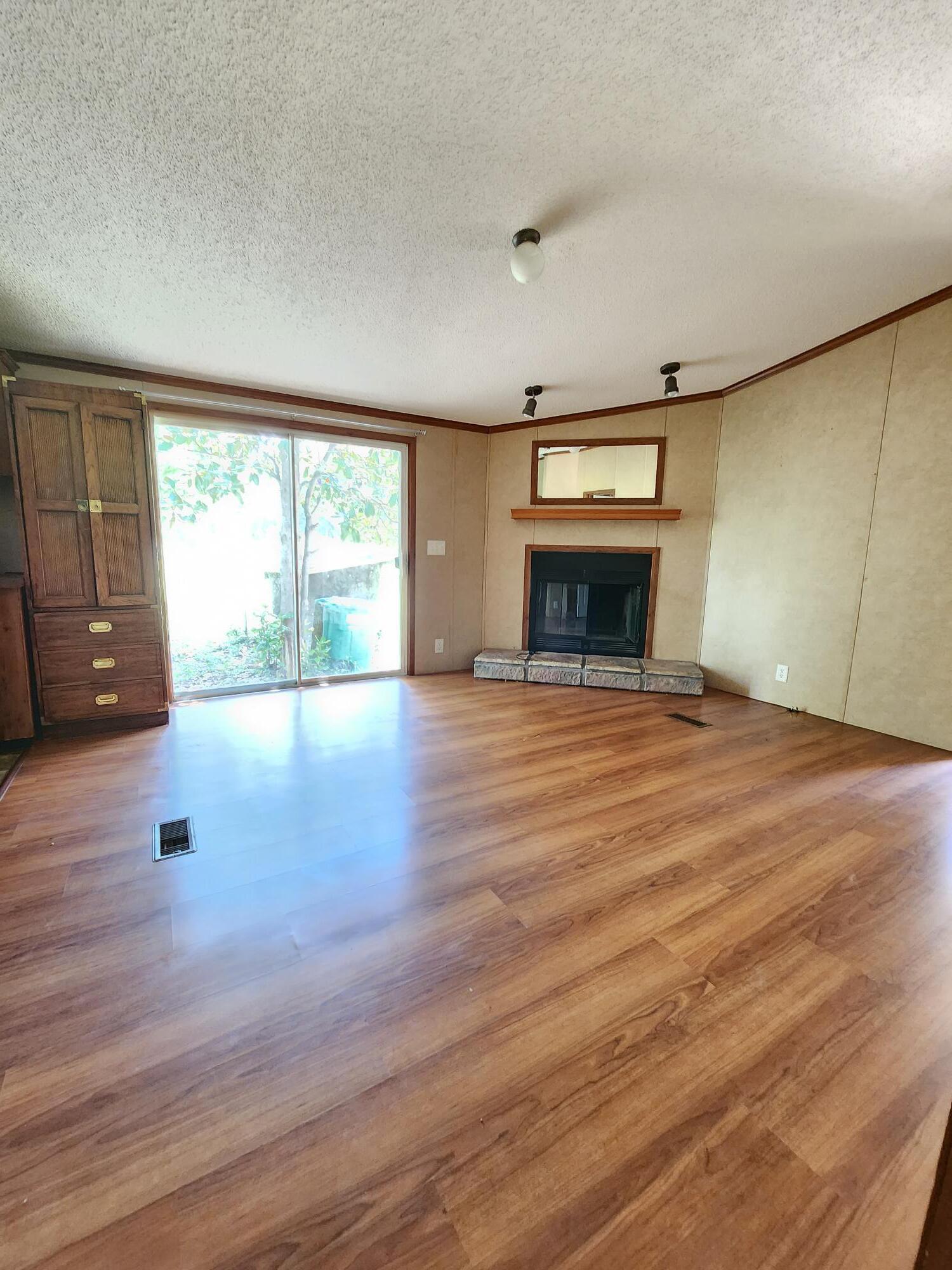 5399 Fox Hound Lane Baker, FL 32531 - Photo 7 of 15 an empty room with wooden floor fireplace and windows