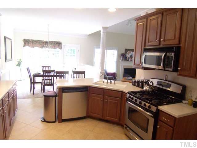 5721 Stuarts Ridge Road Wake Forest, NC 27587 - Photo 4 of 12 3 piece crown molding, 2 piece chair rail, 42? wood cabinets, solid surface counter top and four person breakfast bar, double sinks, gas range, microwave, dishwasher, disposal, five recessed ceiling lights and one florescent light, tile floor.