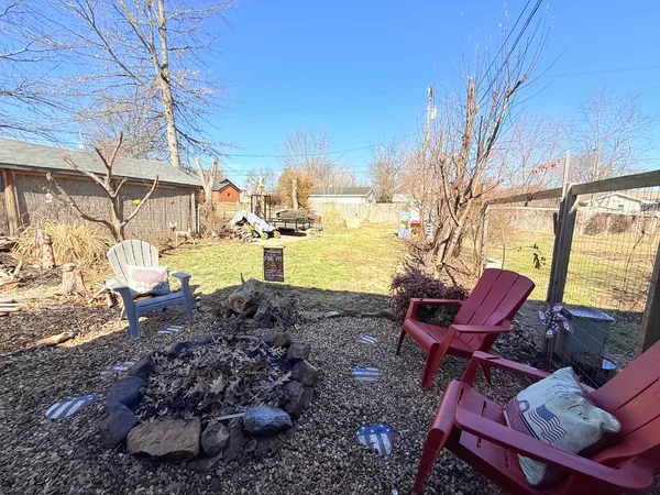 a view of a backyard with table and chairs couches under an umbrella with a small yard