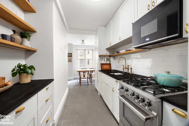a kitchen with stainless steel appliances a sink stove and cabinets