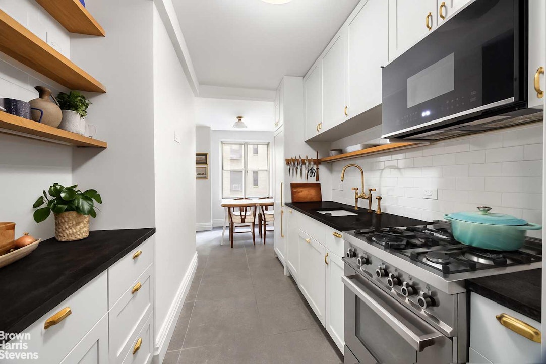 433 East 51st Street, Unit 2F Manhattan, NY 10022 - Photo 2 of 13 a kitchen with stainless steel appliances a sink stove and cabinets