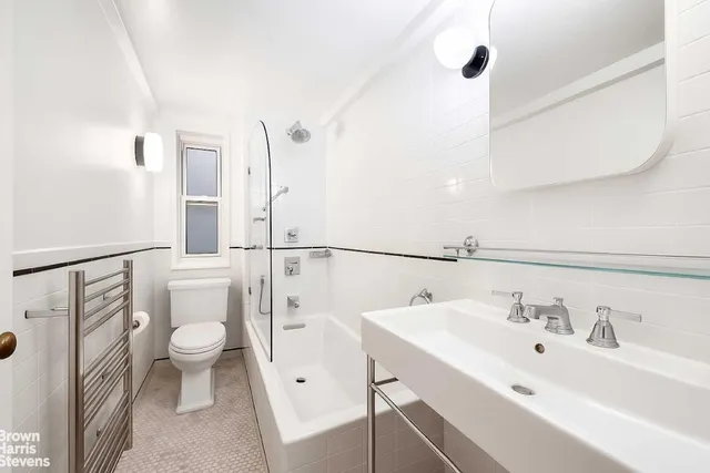 a bathroom with a sink a toilet a mirror and shower