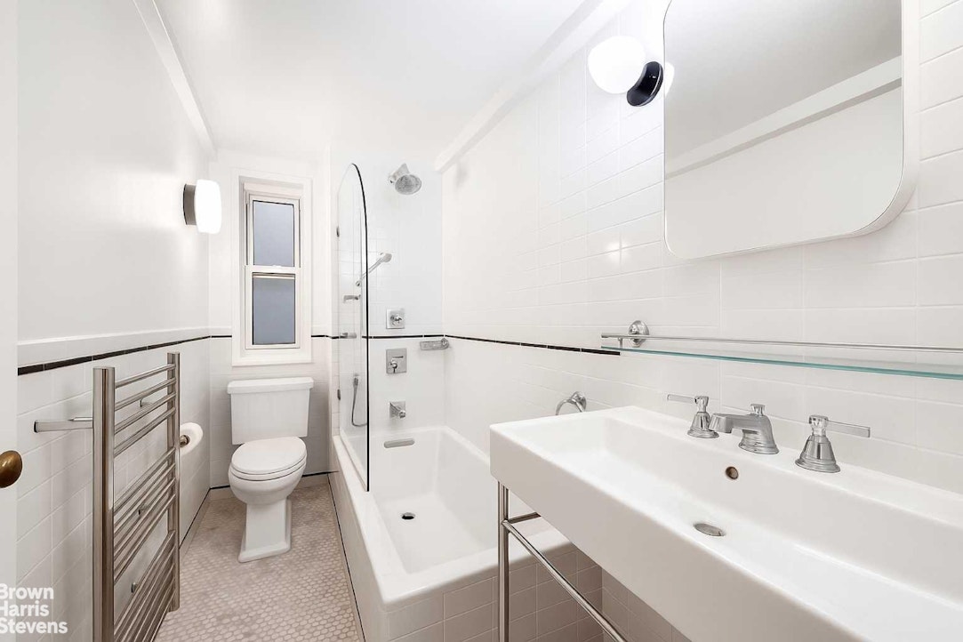 433 East 51st Street, Unit 2F Manhattan, NY 10022 - Photo 4 of 13 a bathroom with a sink a toilet a mirror and shower