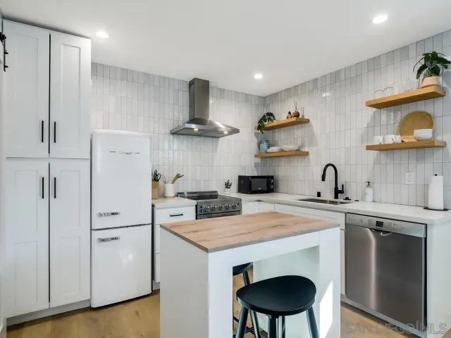 a kitchen with stainless steel appliances a sink stove and refrigerator