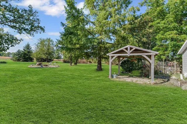 a backyard of a house with table and chairs