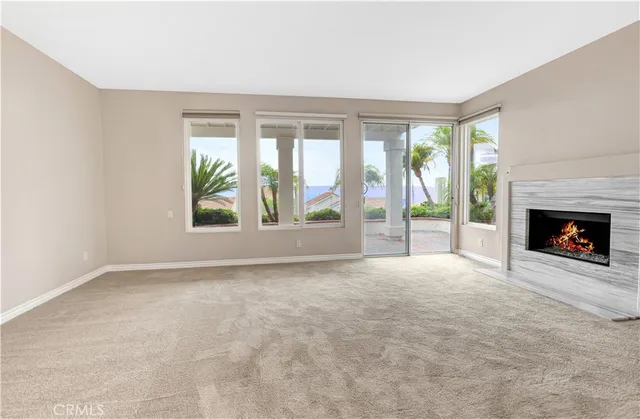 a view of an empty room with a fireplace and a window