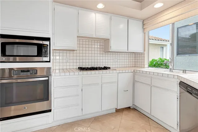 a kitchen with cabinets and stainless steel appliances