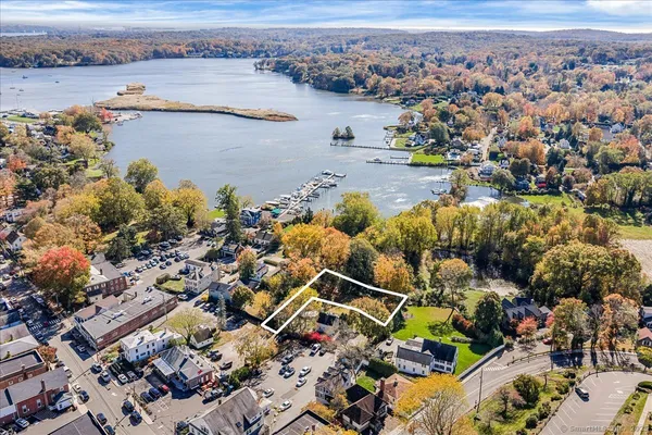 an aerial view of ocean and residential houses with outdoor space