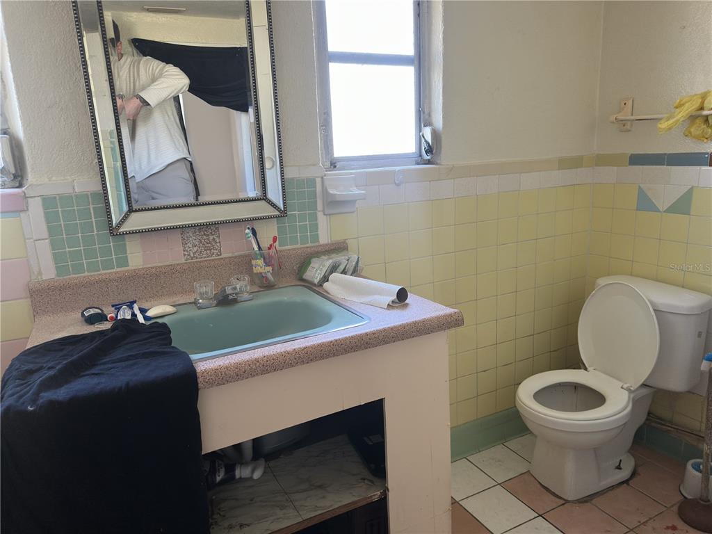 7211 James Street Port Richey, FL 34668 - Photo 11 of 14 a bathroom with a toilet a sink and a mirror