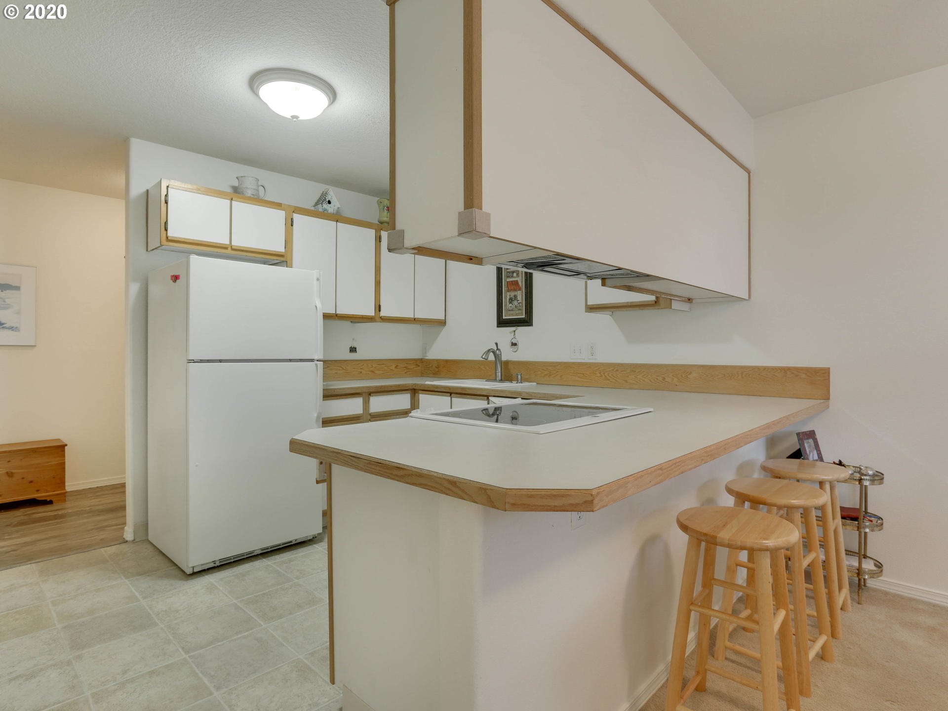 4614 West Powell Boulevard, Unit 261 Gresham, OR 97030 - Photo 12 of 29 a kitchen with a sink a refrigerator and white cabinets