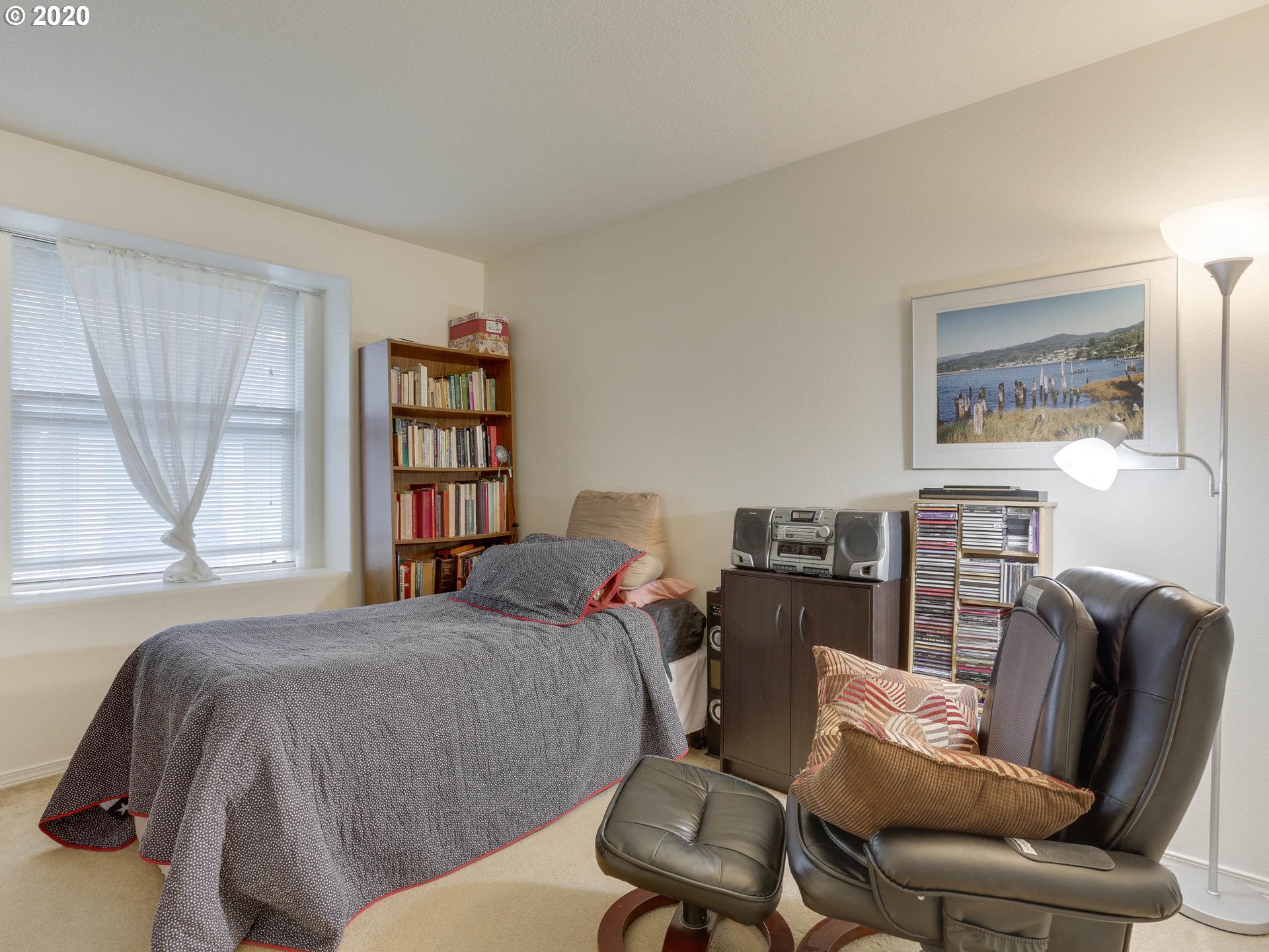 4614 West Powell Boulevard, Unit 261 Gresham, OR 97030 - Photo 23 of 29 a bedroom with a bed a couch and large window
