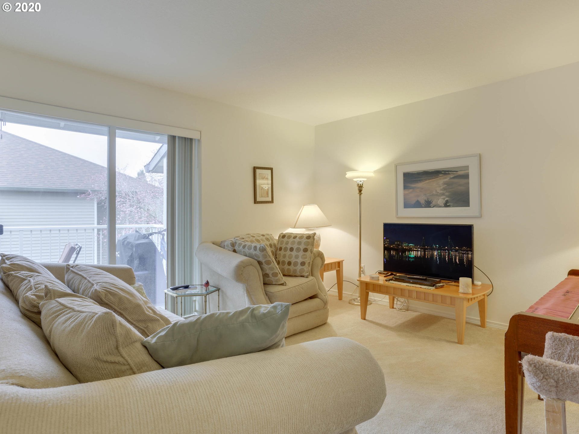 4614 West Powell Boulevard, Unit 261 Gresham, OR 97030 - Photo 5 of 29 a living room with furniture a flat screen tv and a floor to ceiling window