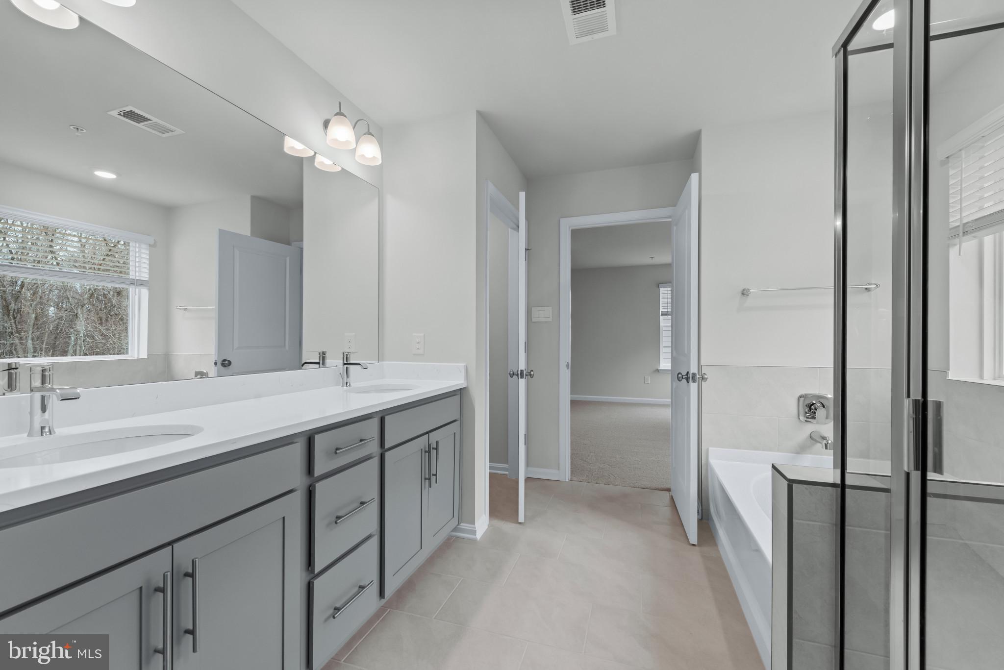 1204 Otter Point Middle River, MD 21220 - Photo 28 of 32 a bathroom with a double vanity sink mirror and shower