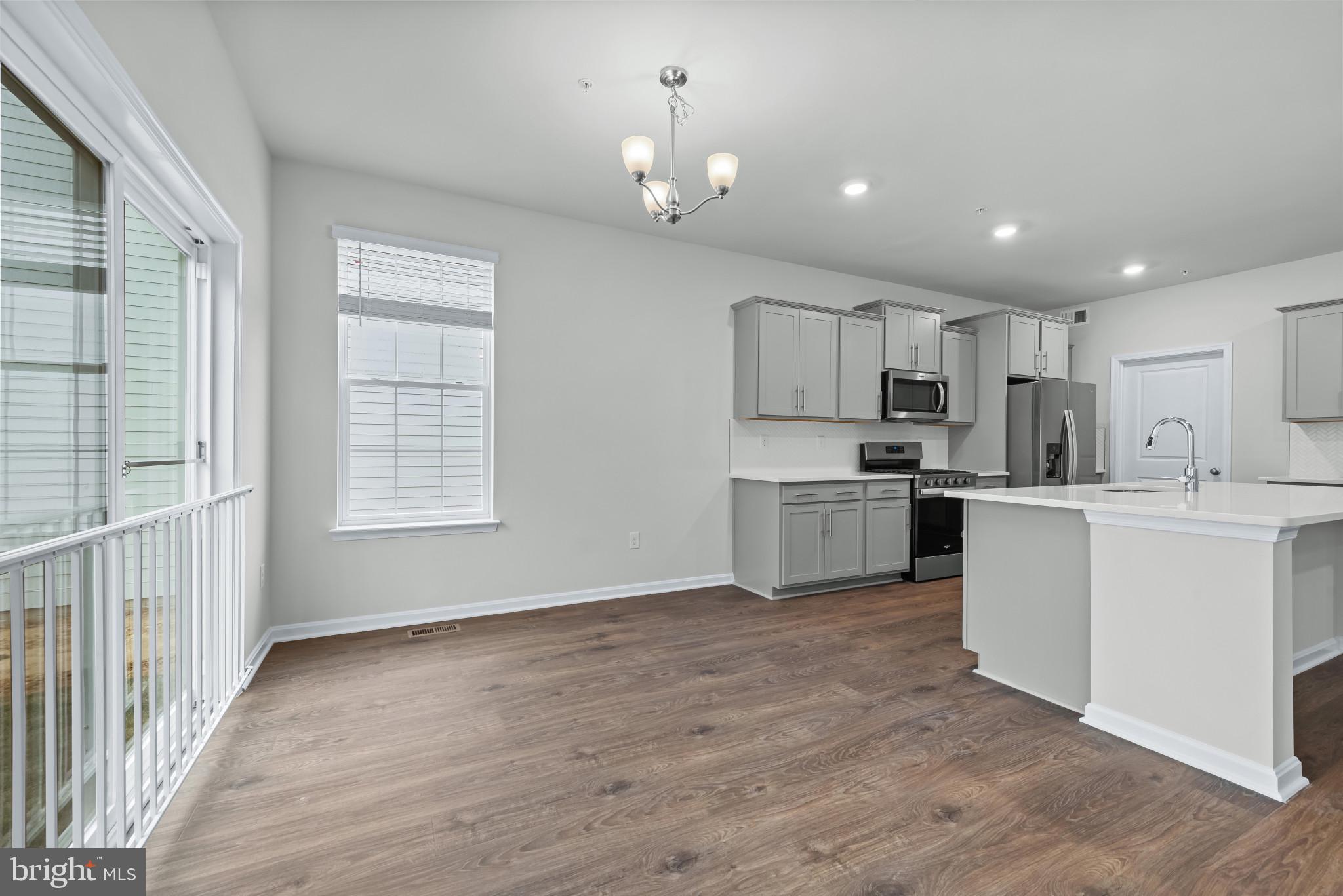 1204 Otter Point Middle River, MD 21220 - Photo 7 of 32 a kitchen with white cabinets and stainless steel appliances