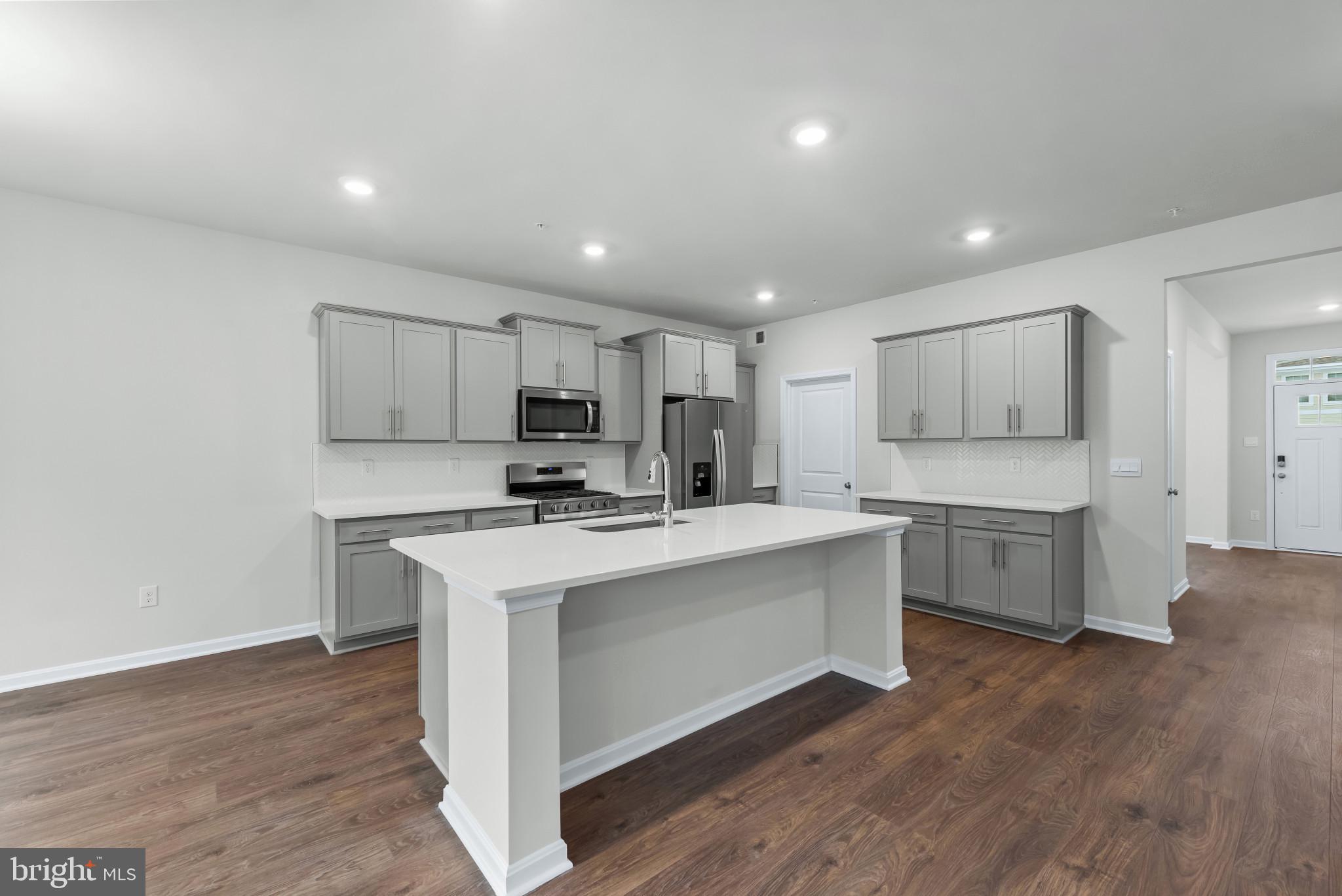 1204 Otter Point Middle River, MD 21220 - Photo 8 of 32 a kitchen with a sink a stove a refrigerator and white cabinets