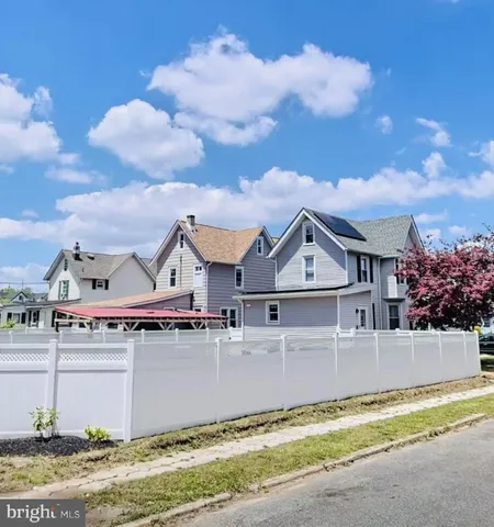 a front view of a house with a garden and trees