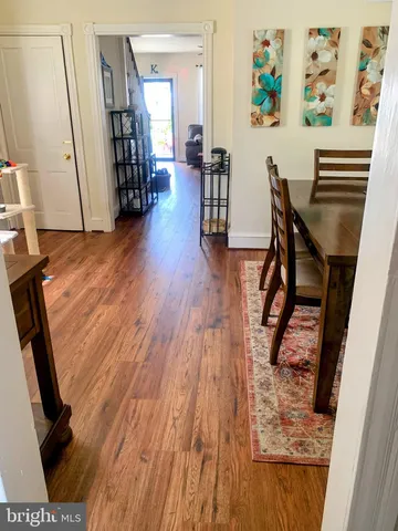 a view of a hallway with wooden floor and furniture