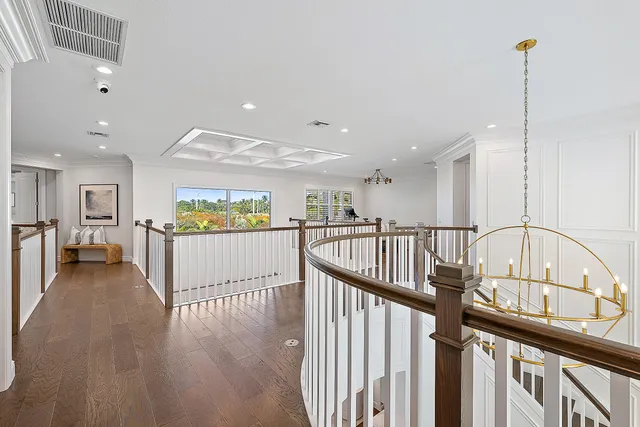 a bedroom with a balcony a bed and a chandelier