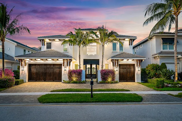 a front view of a house with a garden and a garage