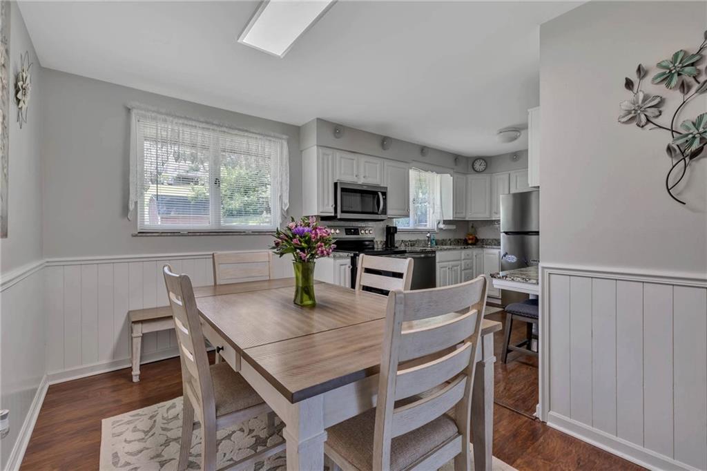 765 Catherine Street Rochester, PA 15074 - Photo 7 of 30 a kitchen with granite countertop a stove a sink a dining table and chairs