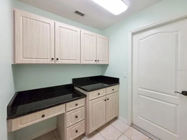 a kitchen with granite countertop white cabinets and sink