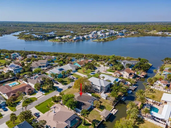 an aerial view of ocean and residential houses with outdoor space