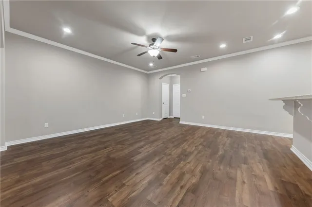 wooden floor in an empty room with a ceiling fan