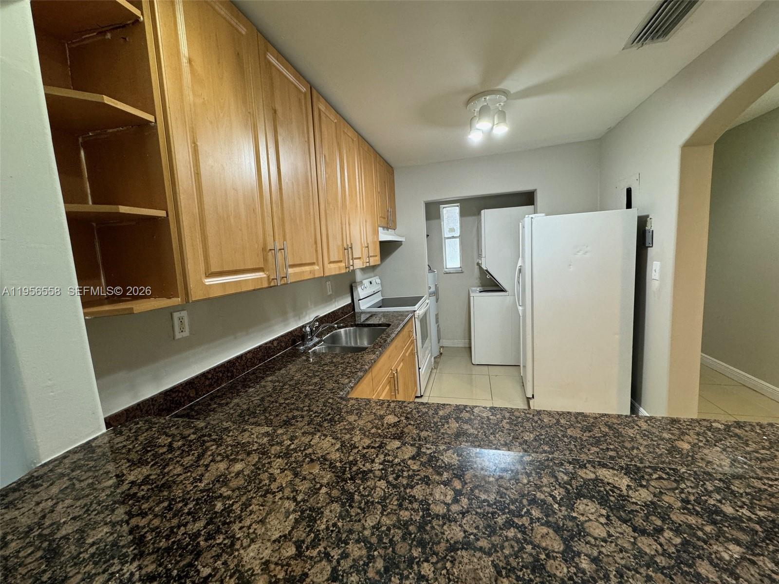 8060 Fairview Drive, Unit 201 Tamarac, FL 33321 - Photo 2 of 33 a view of a refrigerator in kitchen and a window