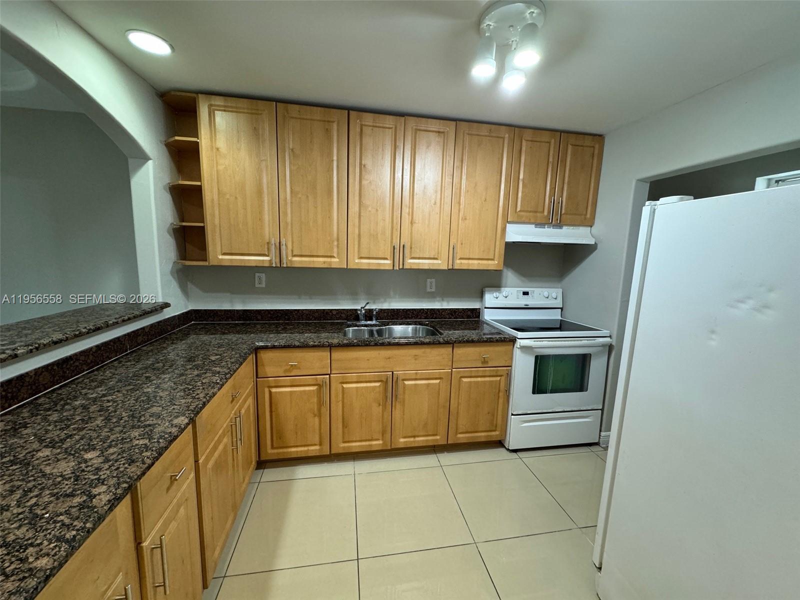 8060 Fairview Drive, Unit 201 Tamarac, FL 33321 - Photo 3 of 33 a kitchen with granite countertop stainless steel appliances and cabinets