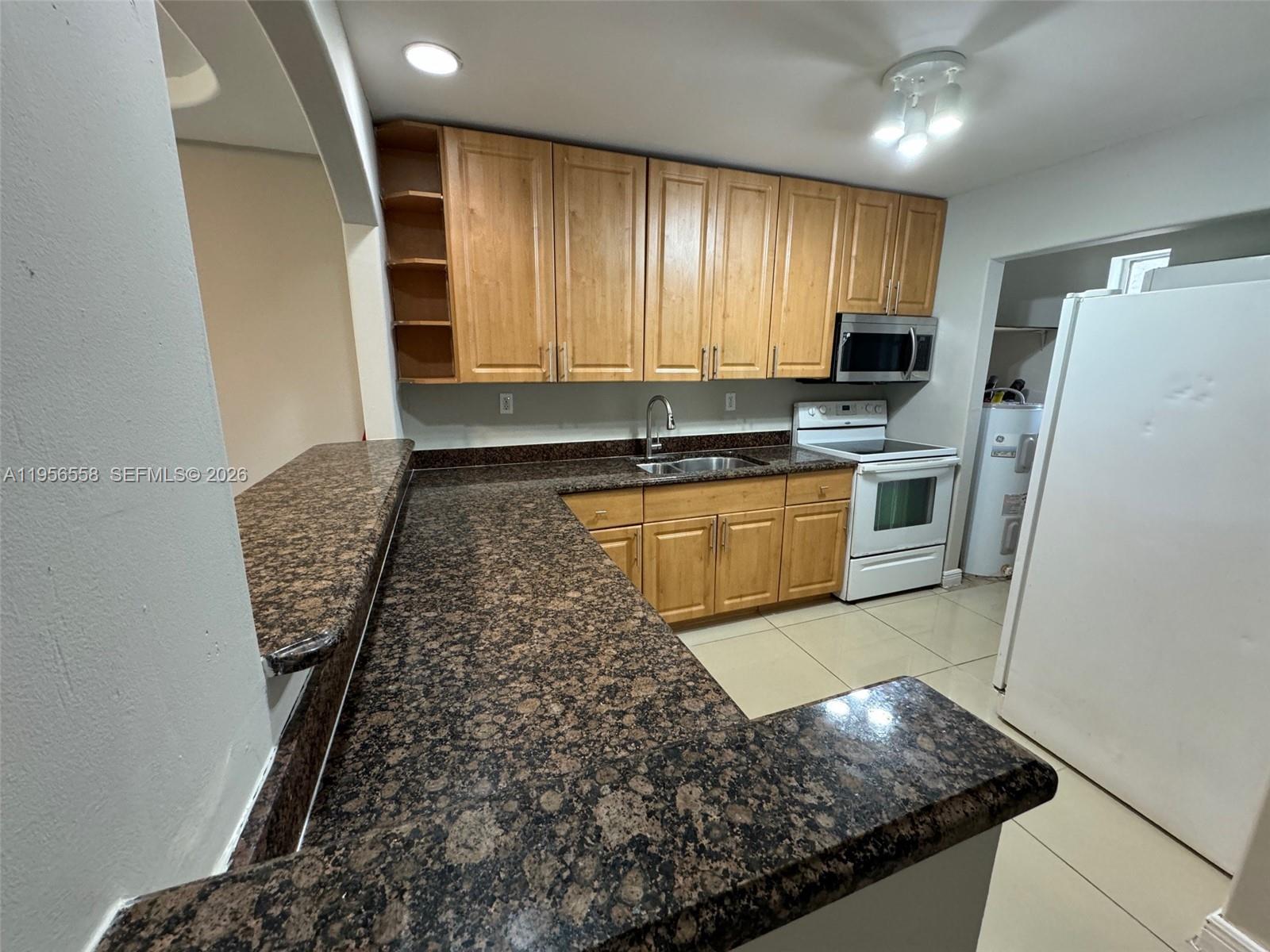 8060 Fairview Drive, Unit 201 Tamarac, FL 33321 - Photo 4 of 33 a kitchen with stainless steel appliances granite countertop a sink stove and refrigerator