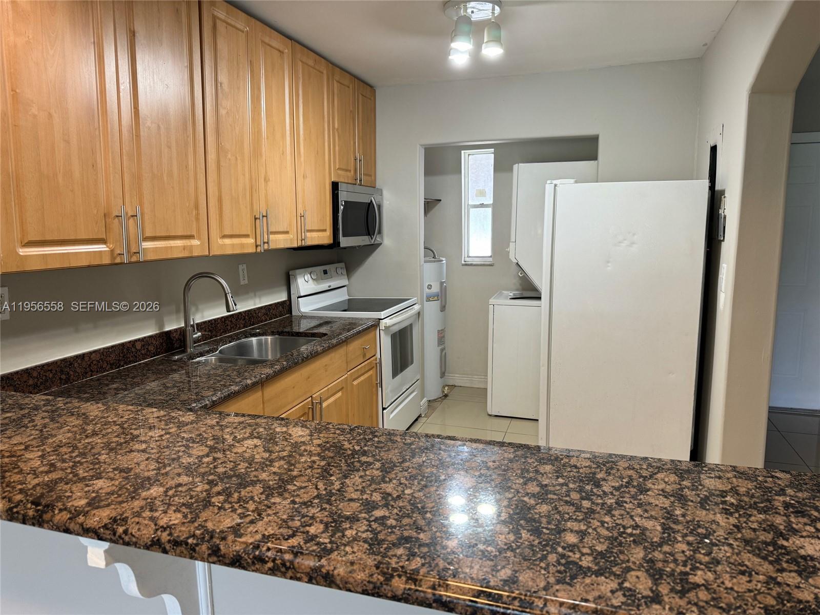 8060 Fairview Drive, Unit 201 Tamarac, FL 33321 - Photo 5 of 33 a kitchen with stainless steel appliances granite countertop a sink stove and refrigerator