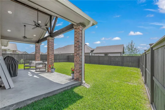a view of a chairs and table in patio with a yard