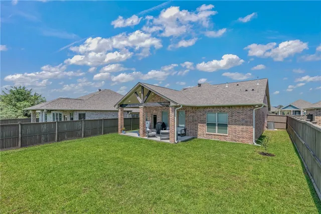 a view of a house with a yard and sitting area