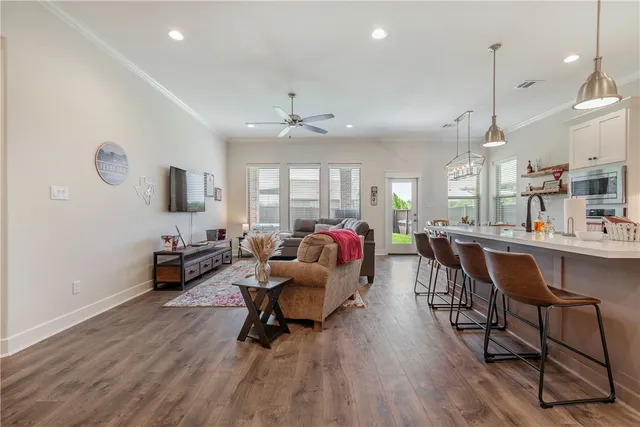 a living room with furniture kitchen view and a large window