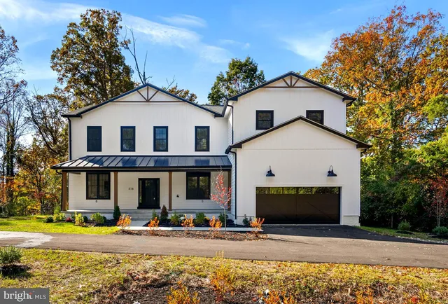 a view of a white house with large windows and a small yard