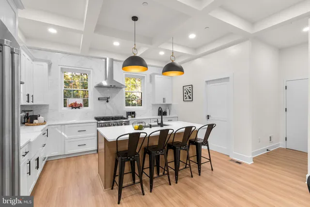 a kitchen with stainless steel appliances granite countertop a sink a stove and a wooden floors