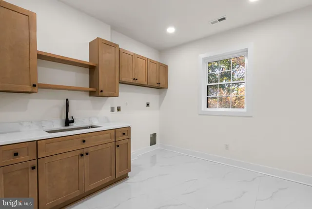 a front view of a house with a yard covered with snow